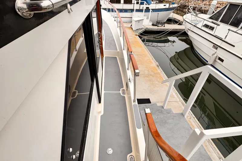 Slide: The Image of 1988 Overseas PT52 Cockpit Motoryacht docked, showcasing side deck and marina view. - 23