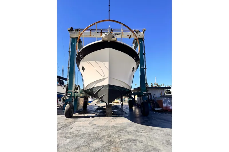 Slide: The Image of 1988 Overseas PT52 Cockpit Motoryacht in dry dock, front view under clear blue sky. - 30