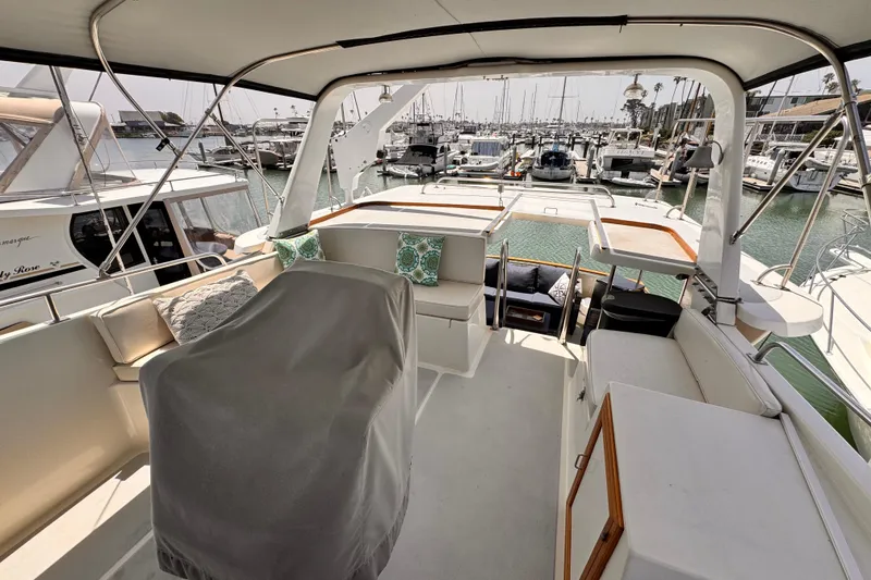 Slide: The Image of 1988 Overseas PT52 Cockpit Motoryacht interior with marina view, featuring seating and covered controls. - 33