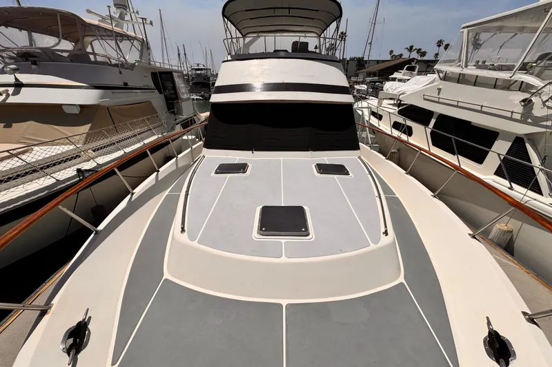 Slide: The Image of 1988 Overseas PT52 Cockpit Motoryacht docked at marina, showcasing spacious deck and sleek design. - 37