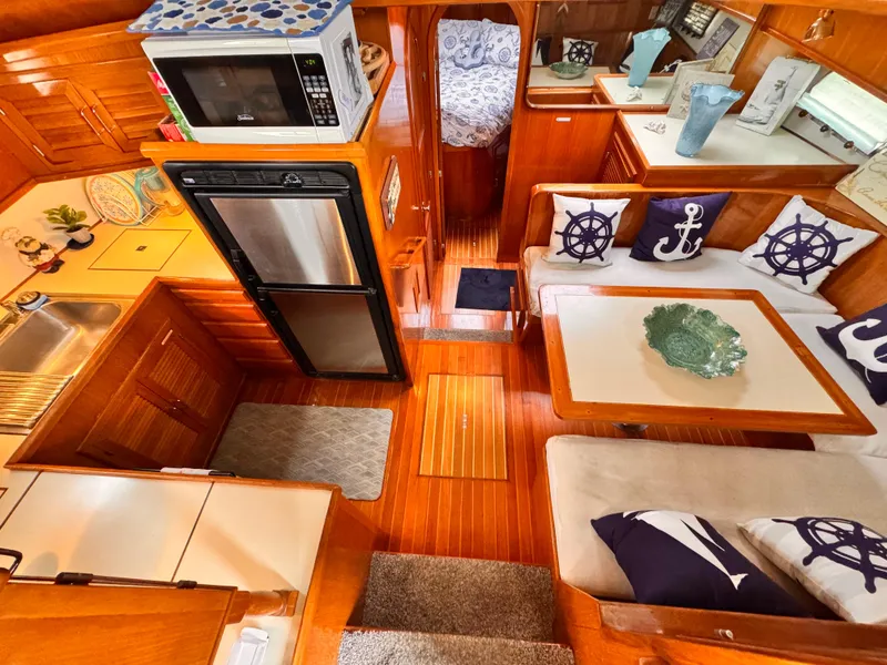 Slide: The Image of Luxurious 1988 Overseas PT52 yacht interior with cozy seating, nautical decor, and modern kitchen amenities. - 7