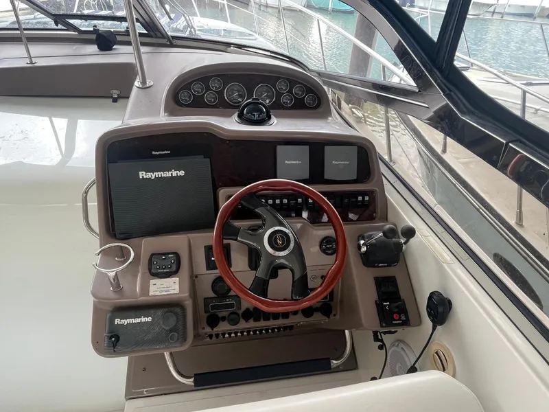 Slide: The Image of 2004 Regal Commodore 4260 boat dashboard with Raymarine navigation system and wooden steering wheel. - 18