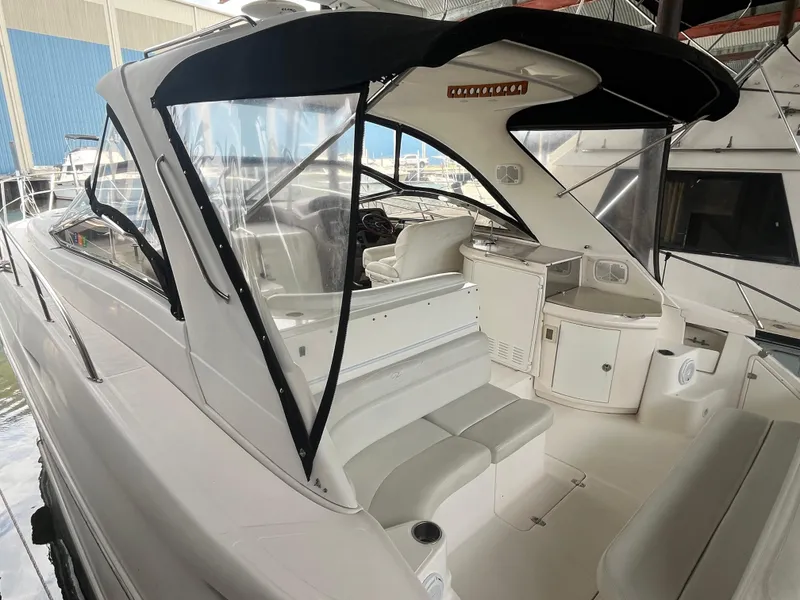 Slide: The Image of 2004 Regal Commodore 4260 yacht interior with seating and helm, docked in marina. - 2