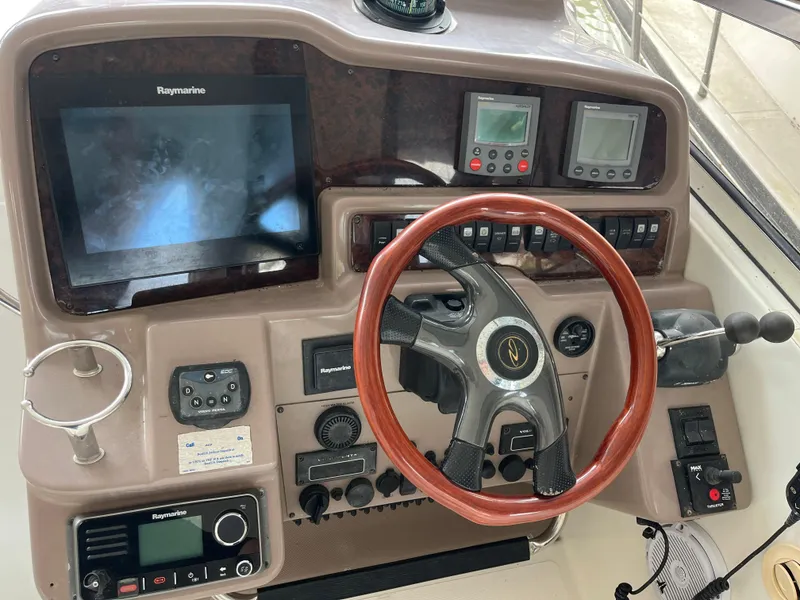 Slide: The Image of 2004 Regal Commodore 4260 helm with wood steering wheel and navigation instruments. - 20