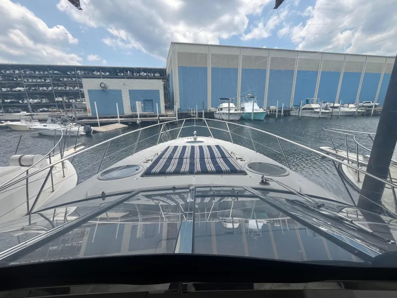 Slide: The Image of 2004 Regal Commodore 4260 yacht docked at marina with blue storage buildings. - 29