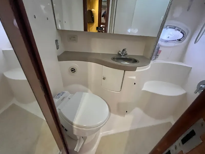 Slide: The Image of 2004 Regal Commodore 4260 yacht bathroom with toilet, sink, and porthole window. - 46
