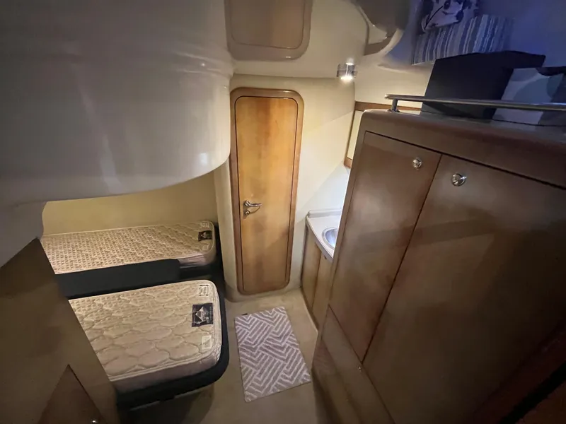 Slide: The Image of Interior of 2004 Regal Commodore 4260 yacht with twin beds and wooden cabinetry. - 47