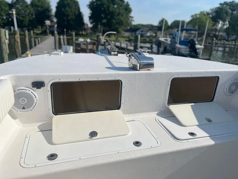 Slide: The Image of 2015 AmeraCat 27 boat dashboard with storage compartments and speakers, docked at a marina. - 19
