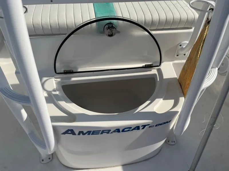 Slide: The Image of Open storage compartment on a 2015 AmeraCat 27 boat, featuring a cushioned seat. - 23