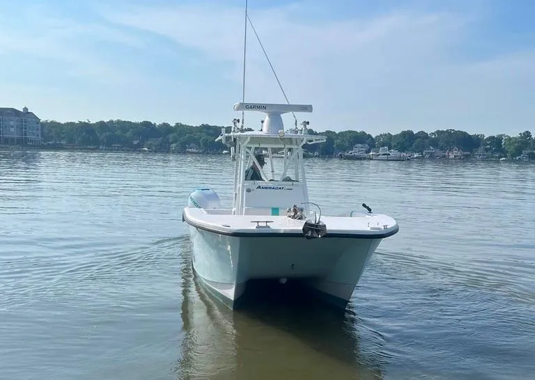 Slide: The Image of 2015 AmeraCat 27 boat on calm water, clear sky, and distant shoreline. - 6