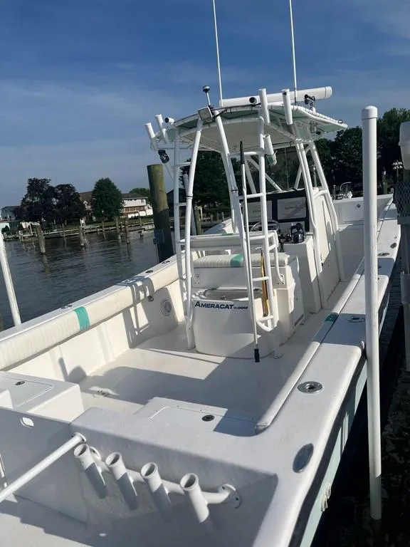 Slide: The Image of 2015 AmeraCat 27 boat docked, featuring spacious deck and fishing rod holders. - 8