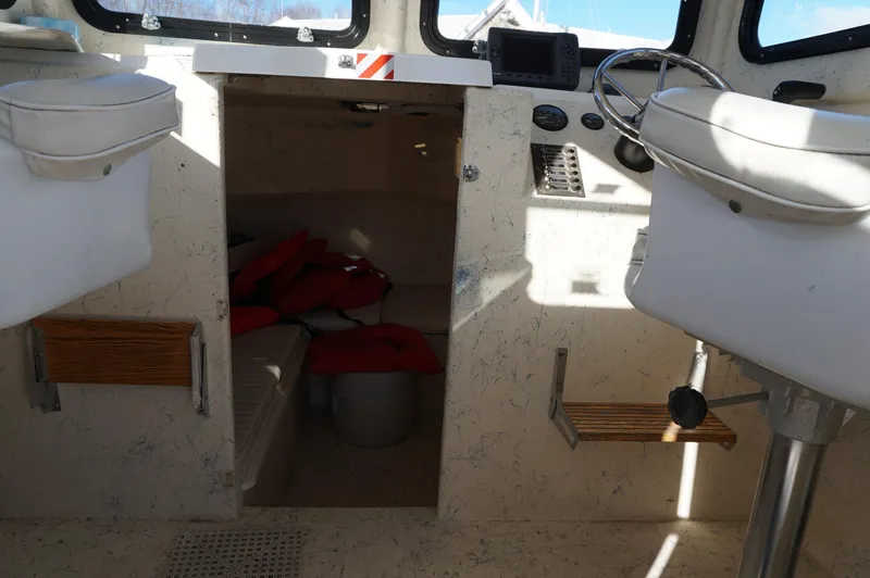 Slide: The Image of Interior of a 2005 Privateer 2400 boat with seating and control panel. - 11