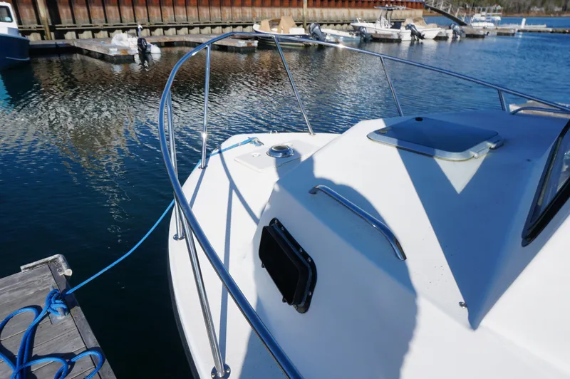 Slide: The Image of Privateer 2400 boat docked at marina, 2005 model, with blue rope and calm water. - 12