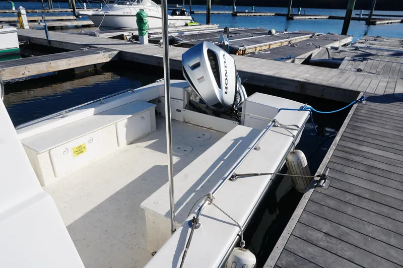 Slide: The Image of Privateer 2400 boat, 2005 model, docked with Honda outboard motor, sunny marina setting. - 15