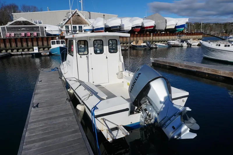 Slide: The Image of 2005 Privateer 2400 boat docked at marina with Honda outboard motor. - 2