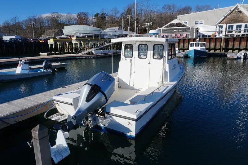 Slide: The Image of 2005 Privateer 2400 boat docked in a marina, featuring an outboard motor. - 3