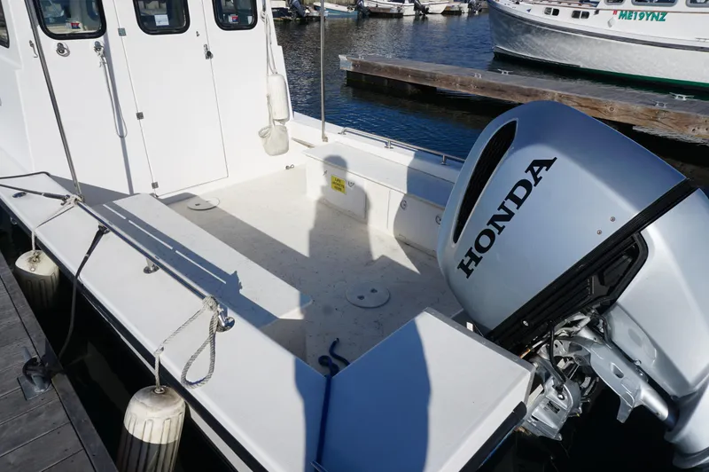 Slide: The Image of Privateer 2400 boat, 2005 model, with Honda outboard motor docked at marina. - 4