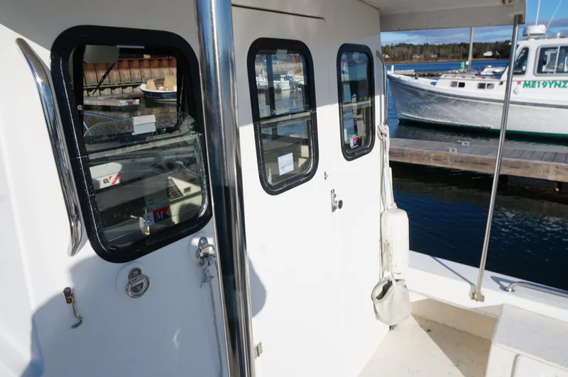 Slide: The Image of Privateer 2400 boat, 2005 model, docked with visible windows and nearby vessels. - 5