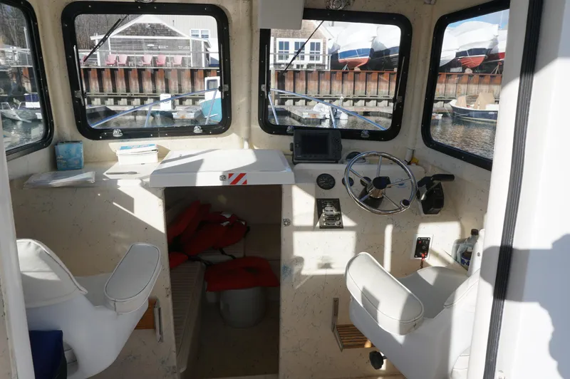 Slide: The Image of Interior of a 2005 Privateer 2400 boat with steering wheel and seating. - 7