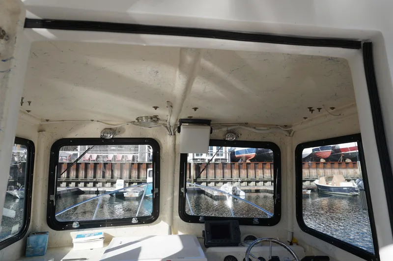 Slide: The Image of Interior view of a 2005 Privateer 2400 boat cabin with dockside windows. - 9