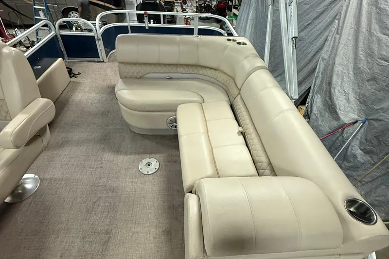 Slide: The Image of Luxurious seating on a 2021 Ranger 223FC boat, featuring beige upholstery and cup holders. - 10