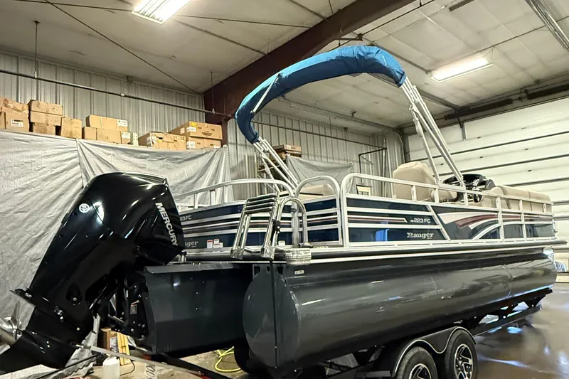 Slide: The Image of 2021 Ranger 223FC pontoon boat with Mercury outboard motor in a storage facility. - 4