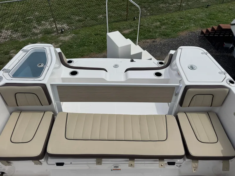 Slide: The Image of 2025 Yamaha Boats 255 FSH Sport E interior with beige seating and storage compartments. - 10
