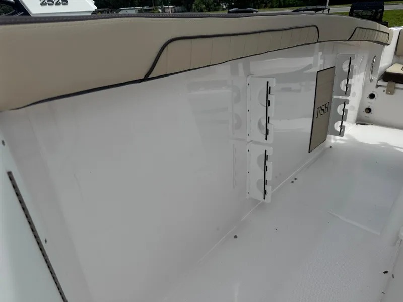 Slide: The Image of 2025 Yamaha Boats 255 FSH Sport E interior with beige seating and storage compartments. - 11