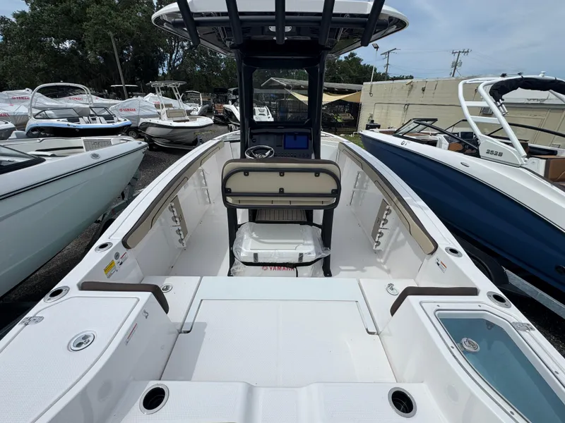 Slide: The Image of 2025 Yamaha Boats 255 FSH Sport E, sleek interior view, docked among other boats. - 3