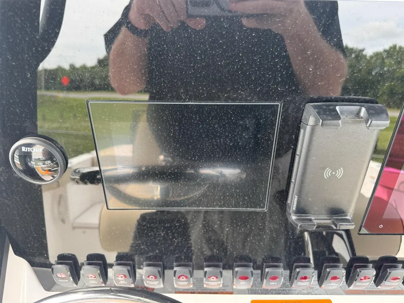 Slide: The Image of Control panel of 2025 Yamaha Boats 255 FSH Sport E with compass and switches. - 8