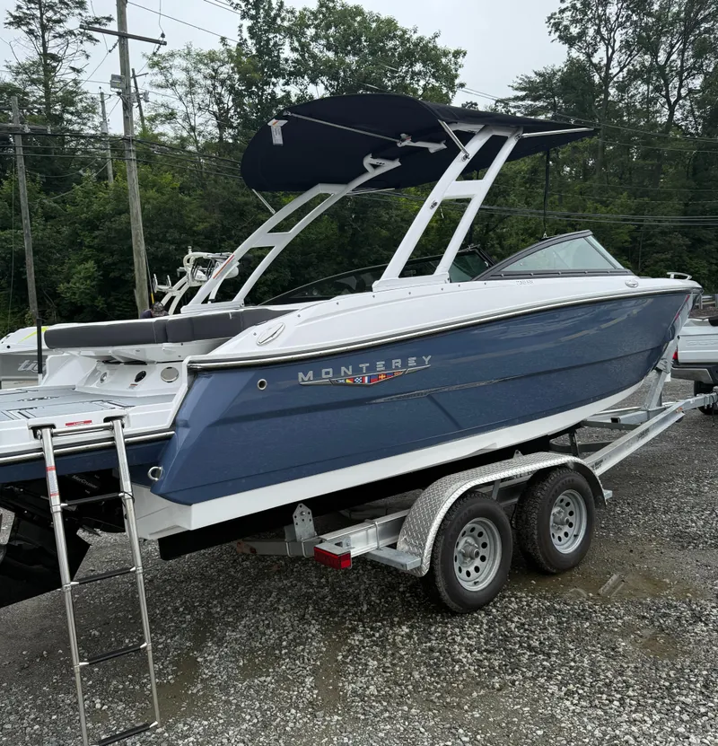 Slide: The Image of 2025 Monterey 238 Super Sport boat on trailer, blue exterior, parked outdoors. - 2