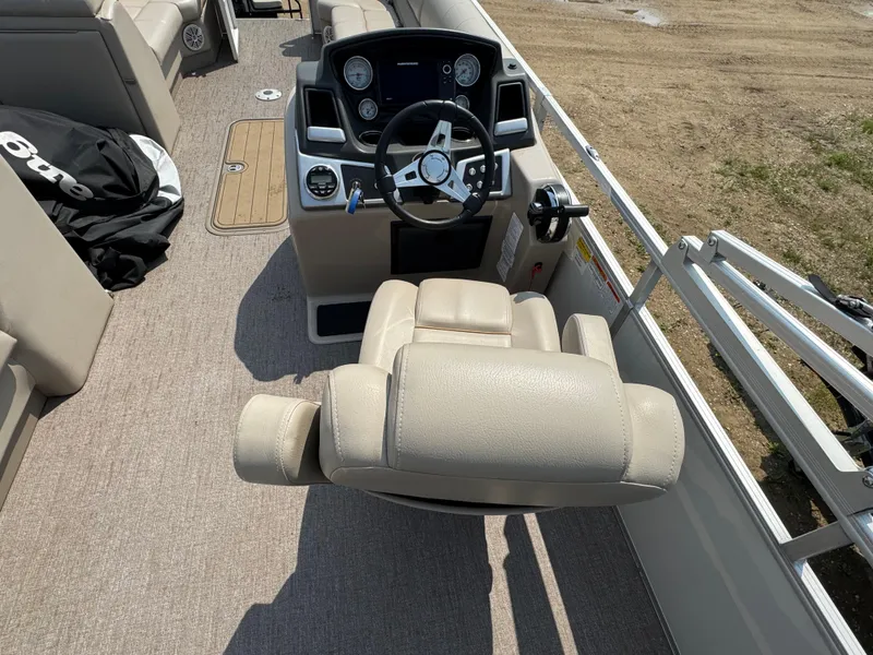 Slide: The Image of Captain's seat and helm of 2020 Ranger Reata 223C boat, featuring beige upholstery. - 12