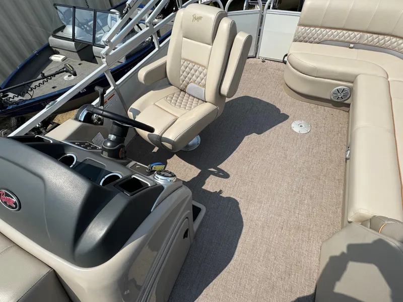 Slide: The Image of 2020 Ranger Reata 223C boat interior with beige seating and steering console. - 8