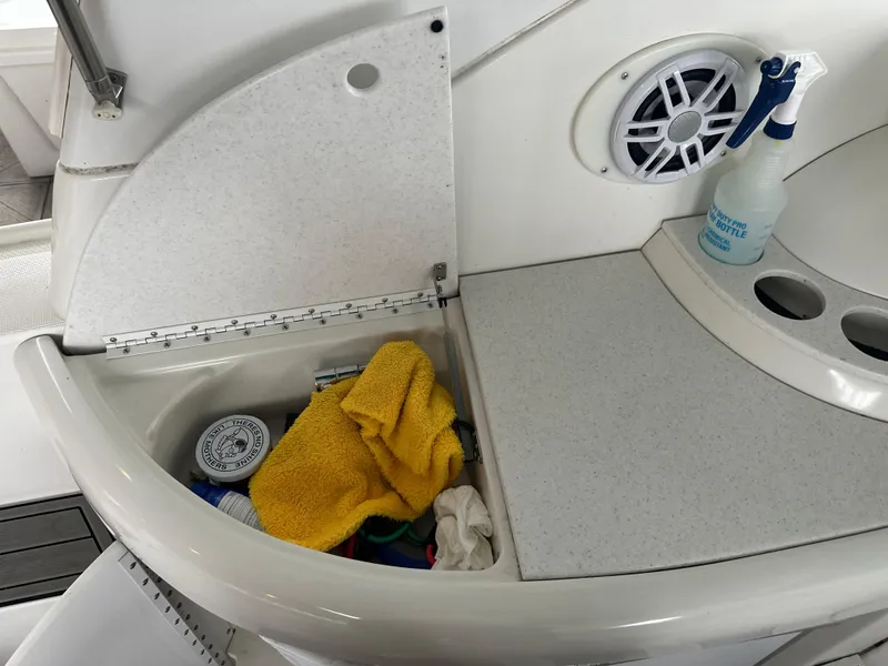 Slide: The Image of Storage compartment on a 2000 Formula 40 PC boat with cleaning supplies and speaker. - 25