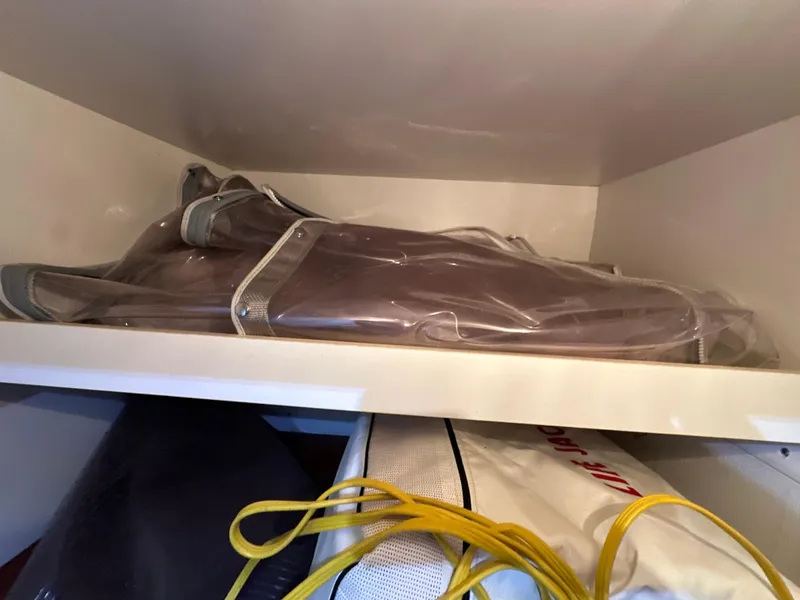 Slide: The Image of Stored items in a shelf, including a wrapped cover, possibly for a 2000 Formula 40 PC. - 33