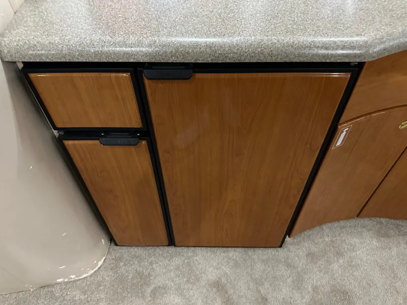 Slide: The Image of Wooden cabinet with countertop in a 2000 Formula 40 PC boat interior. - 41