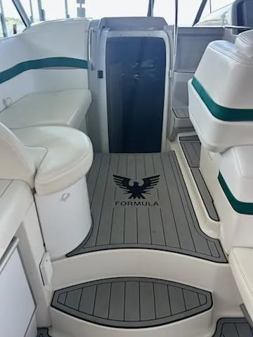 Slide: The Image of Interior of a 2000 Formula 40 PC boat with white seating and logo on the floor. - 43