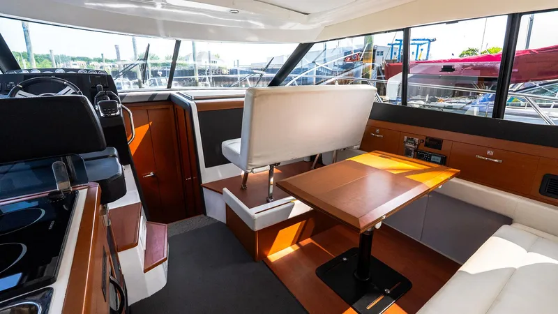Slide: The Image of 2018 Jeanneau NC11 interior with modern seating, table, and helm station. - 12
