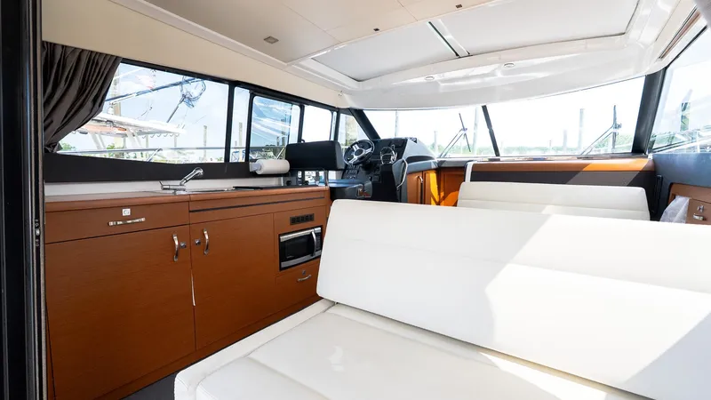 Slide: The Image of Interior of 2018 Jeanneau NC11 yacht with modern seating and kitchen area. - 14