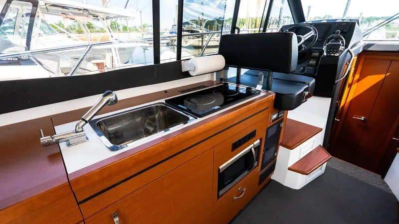 Slide: The Image of Interior of 2018 Jeanneau NC11 boat with kitchen and helm station. - 19