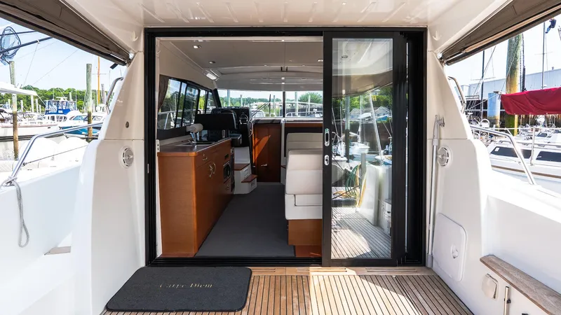 Slide: The Image of 2018 Jeanneau NC11 yacht interior with sliding glass doors and wooden flooring. - 4