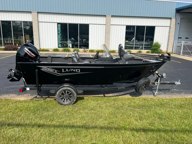 The Image of 2026 Lund 1650 Rebel XL SS boat on trailer, parked outside a building. - 0