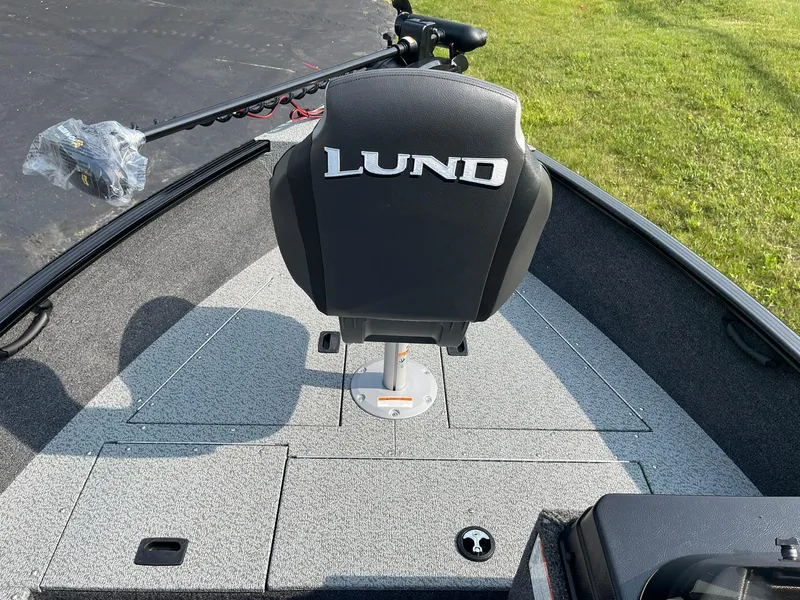 Slide: The Image of 2026 Lund 1650 Rebel XL SS boat interior with branded seat and fishing equipment. - 11