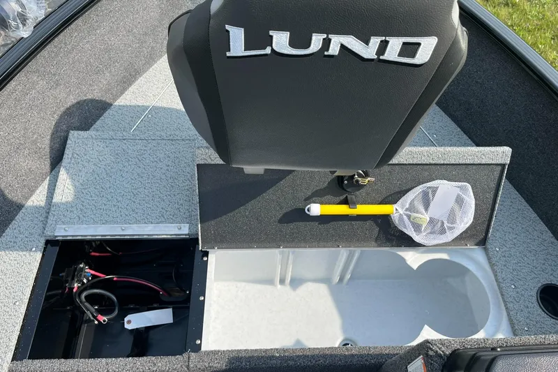 Slide: The Image of 2026 Lund 1650 Rebel XL SS boat interior with storage compartments and fishing net. - 12