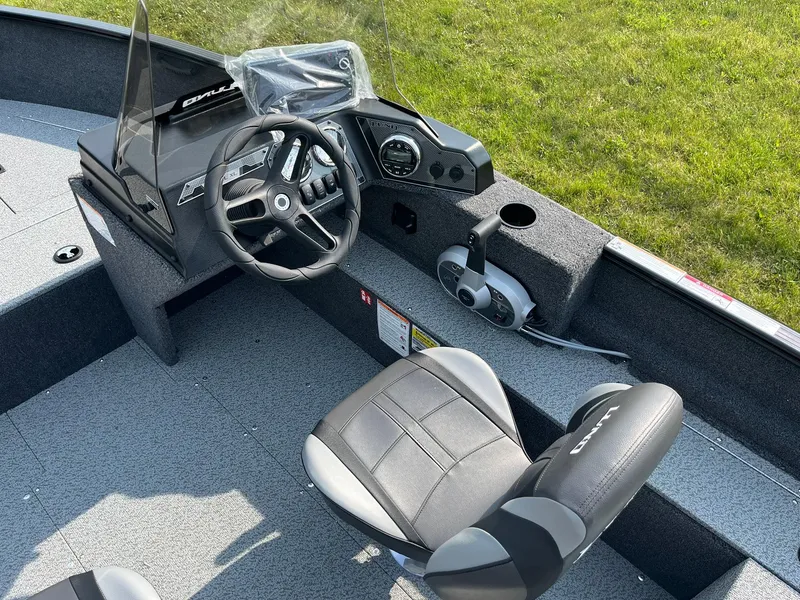 Slide: The Image of 2026 Lund 1650 Rebel XL SS boat interior with steering wheel and seating. - 14