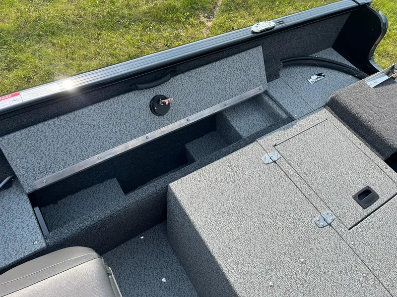 Slide: The Image of 2026 Lund 1650 Rebel XL SS boat interior with storage compartments and seating. - 19