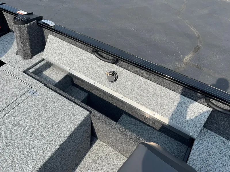 Slide: The Image of 2026 Lund 1650 Rebel XL SS boat interior with storage compartments and textured flooring. - 20