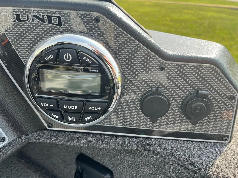 Slide: The Image of 2026 Lund 1650 Rebel XL SS dashboard with audio controls and power outlets. - 21