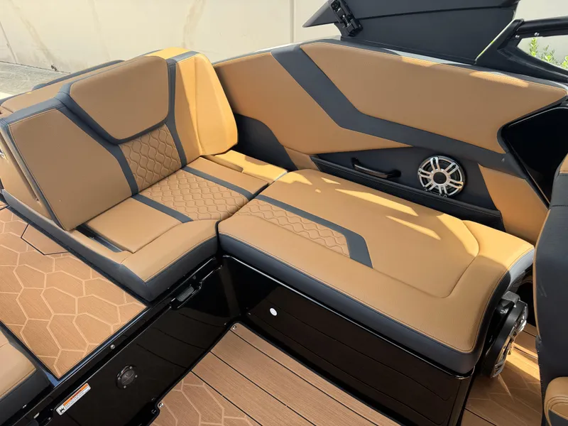 Slide: The Image of 2025 Yamaha Boats 255XD interior with tan and black seating, featuring modern design and speaker system. - 21