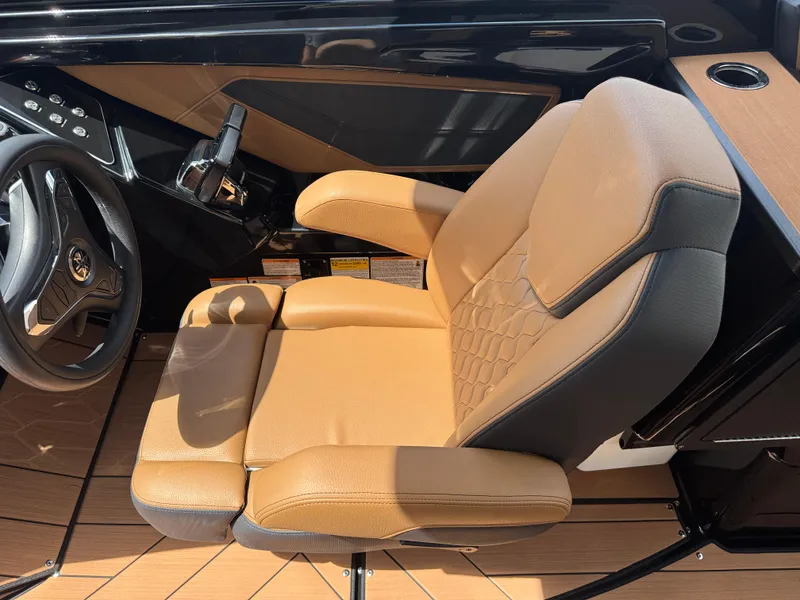 Slide: The Image of Captain's seat in 2025 Yamaha Boats 255XD, featuring tan upholstery and modern design. - 25